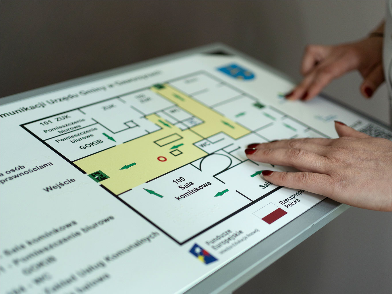 Dłonie kobiety dotykają planu tyflograficznego